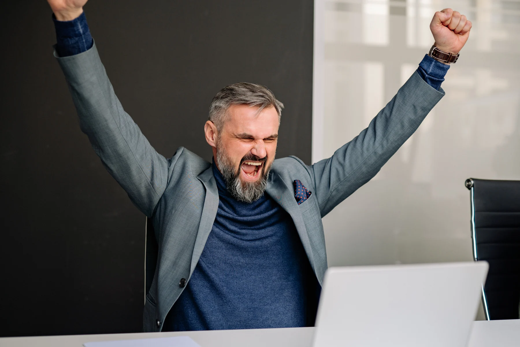 Professionista celebra un risultato davanti a un computer